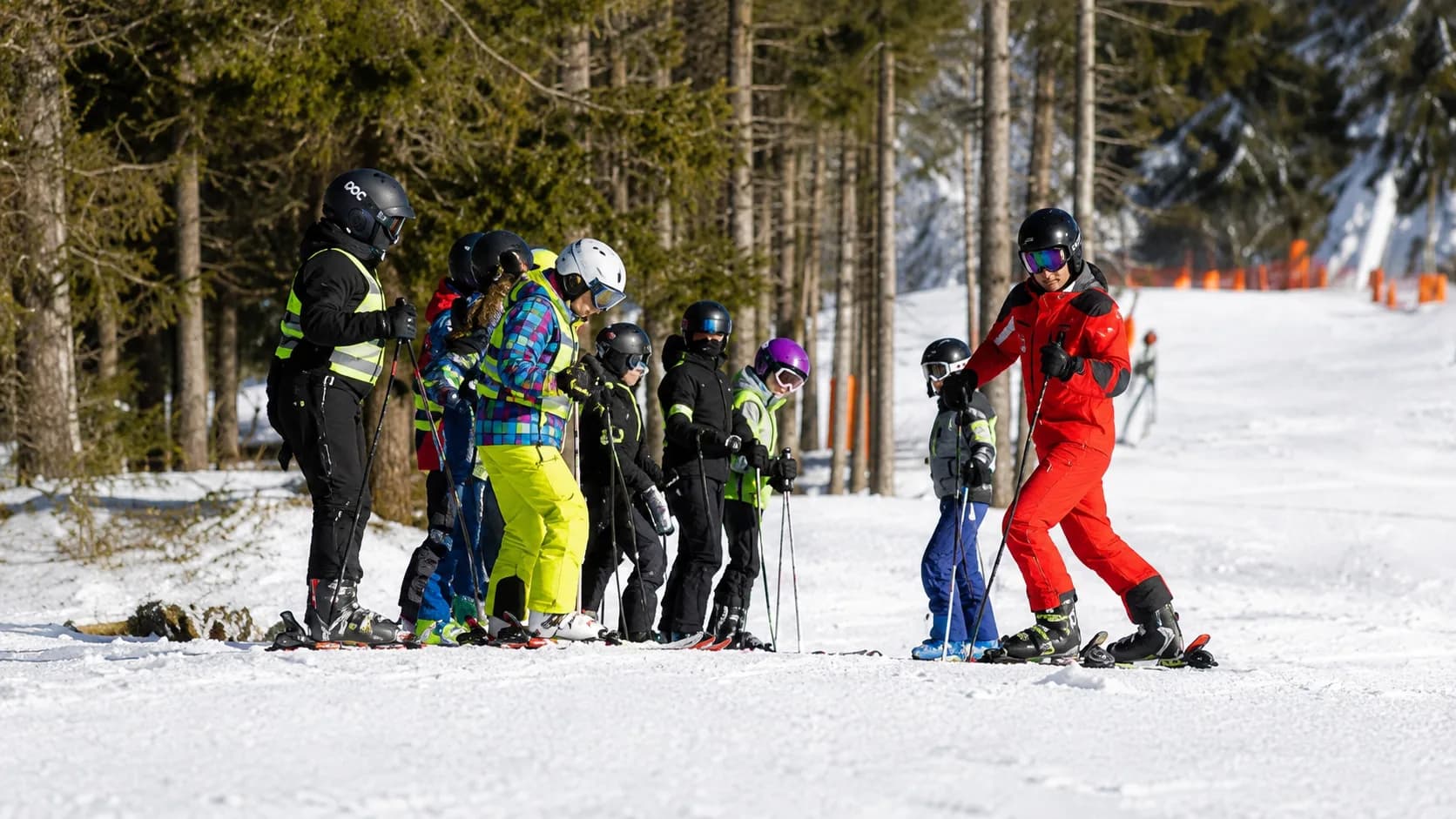 Instructor guiando una clase de esquí para niños en la nieve
