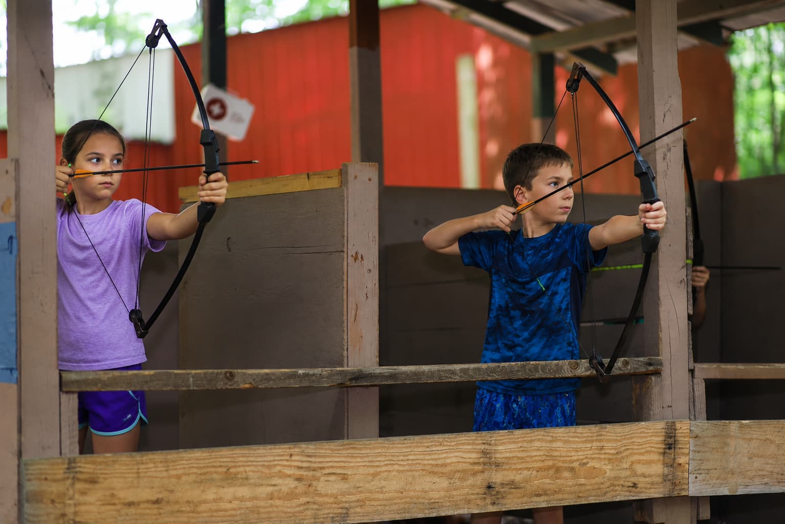 Niños practicando tiro con arco en el campamento